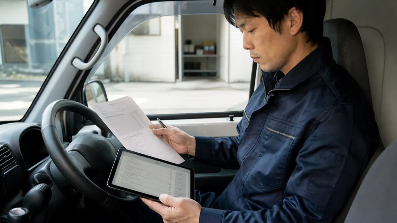 軽貨物ドライバーが出発前に発注書とメールの契約条件を照合する様子